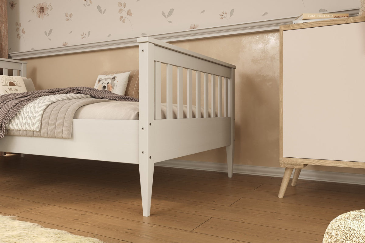 1. White wooden bed in a cozy bedroom setting with floral wallpaper and wooden flooring