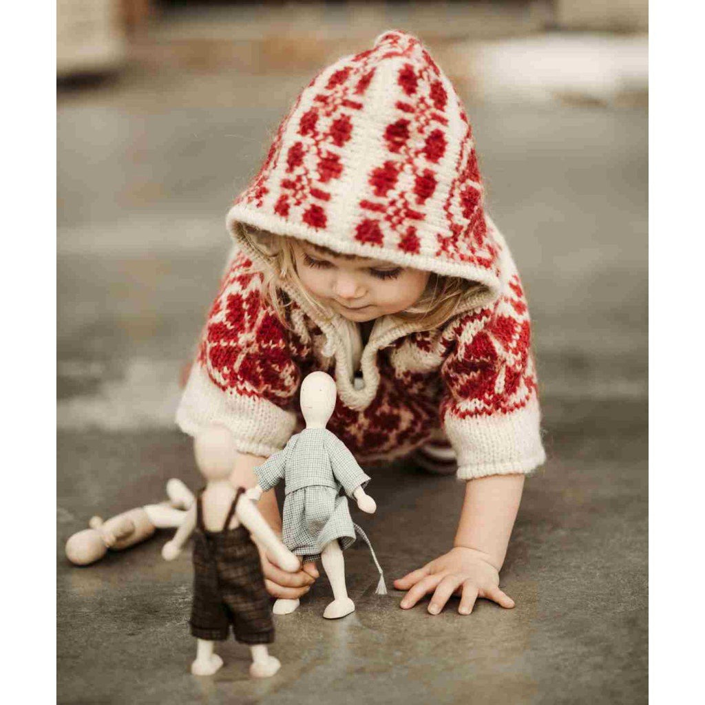 13. Child in red patterned sweater crawling towards Wooden Story beech dolls on floor