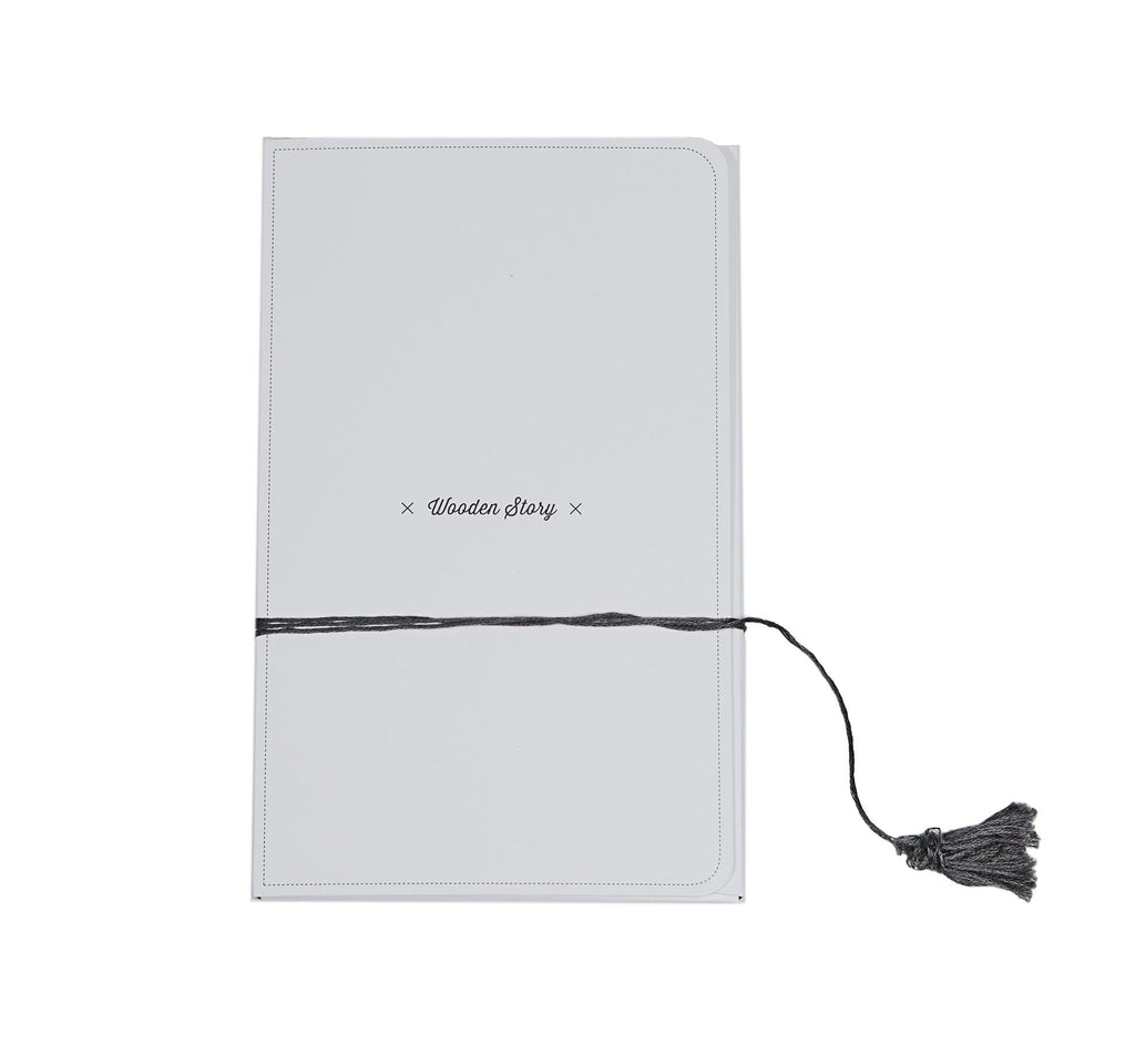 4. Flat lay of Wooden Story packaging with black tassel on white box