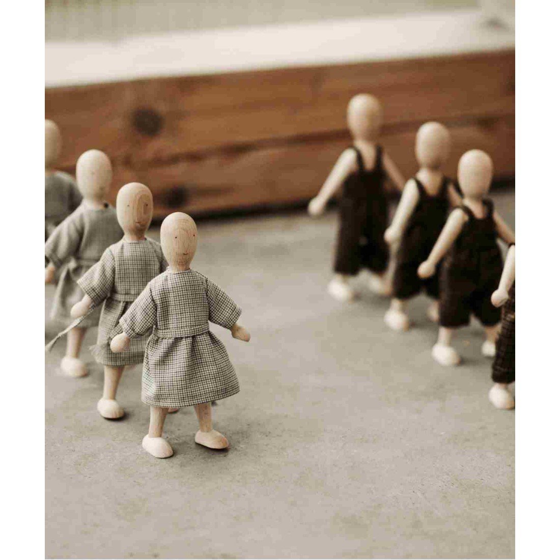 1. Group of Wooden Beech Dolls in dresses and pants on concrete floor