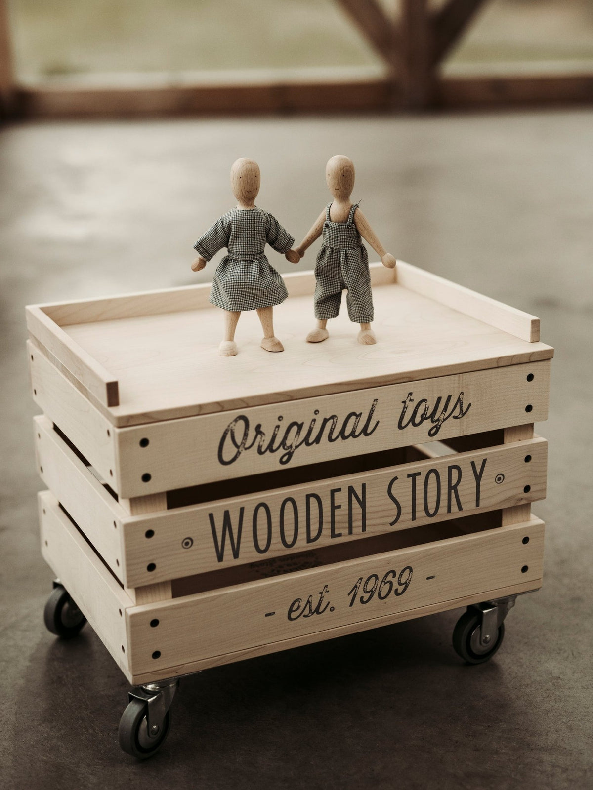 1. Two wooden beech dolls on a wooden crate with 'Wooden Story' text