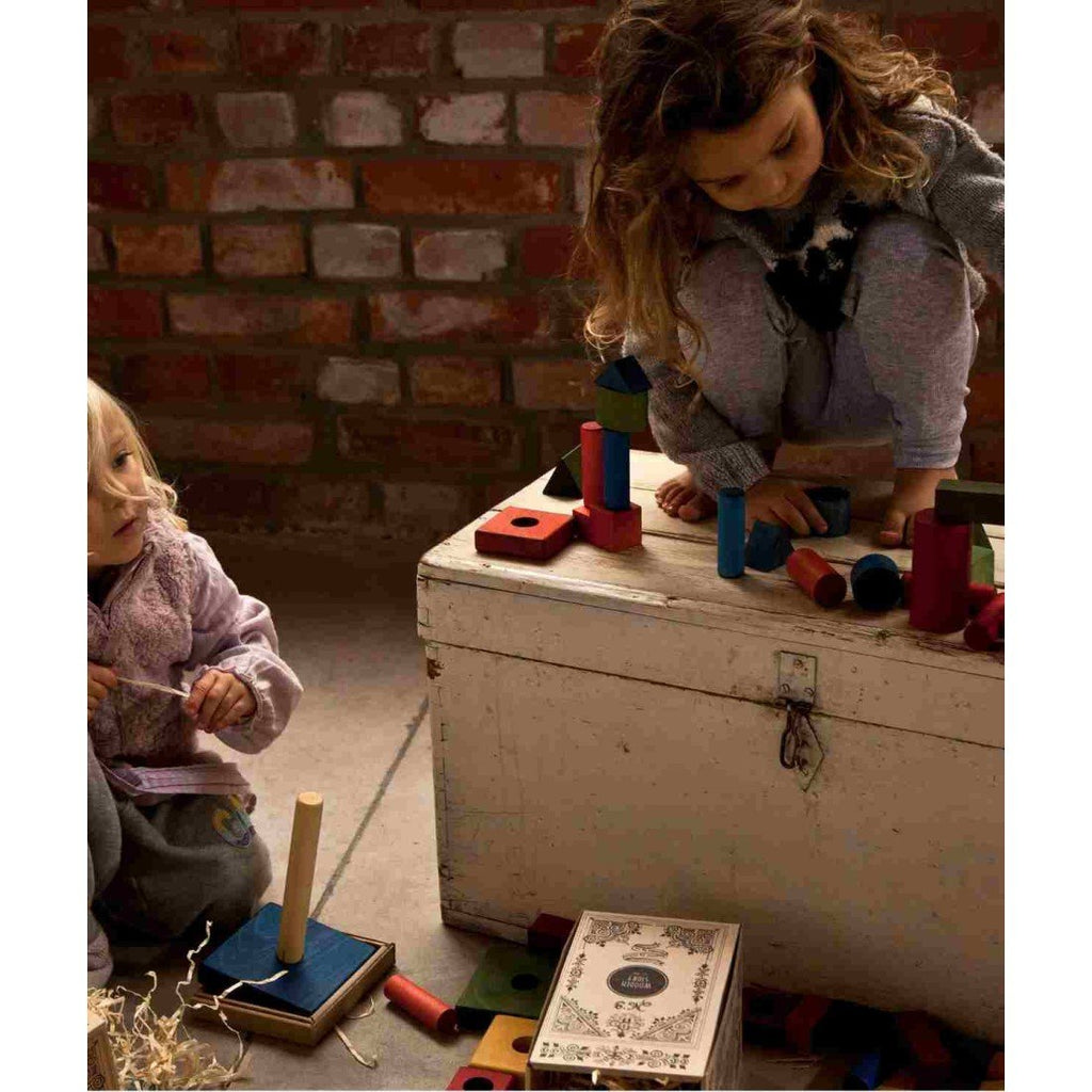 1. Two children playing with colorful wooden blocks in a rustic indoor setting
