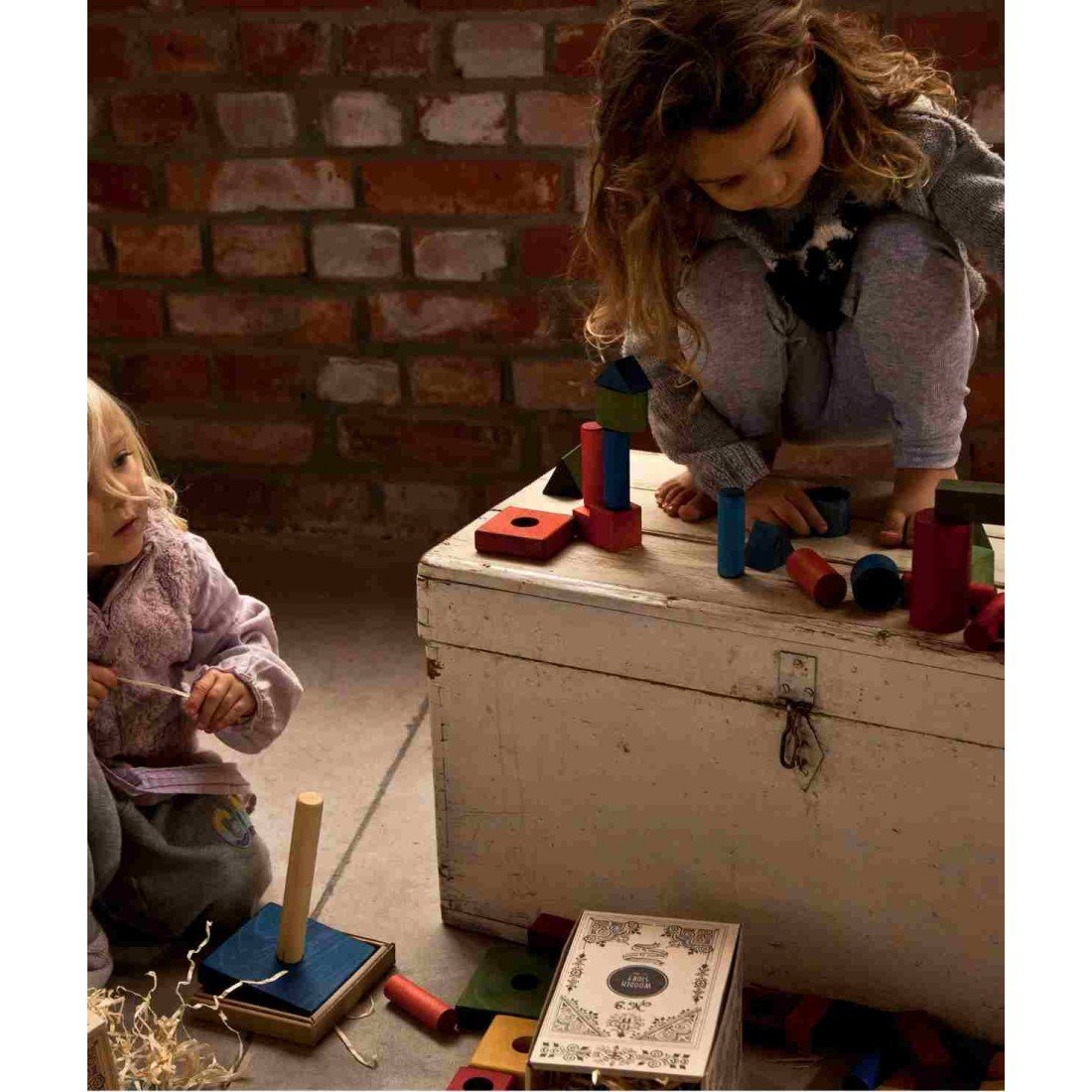 1. Two children playing with colorful wooden blocks in a rustic indoor setting