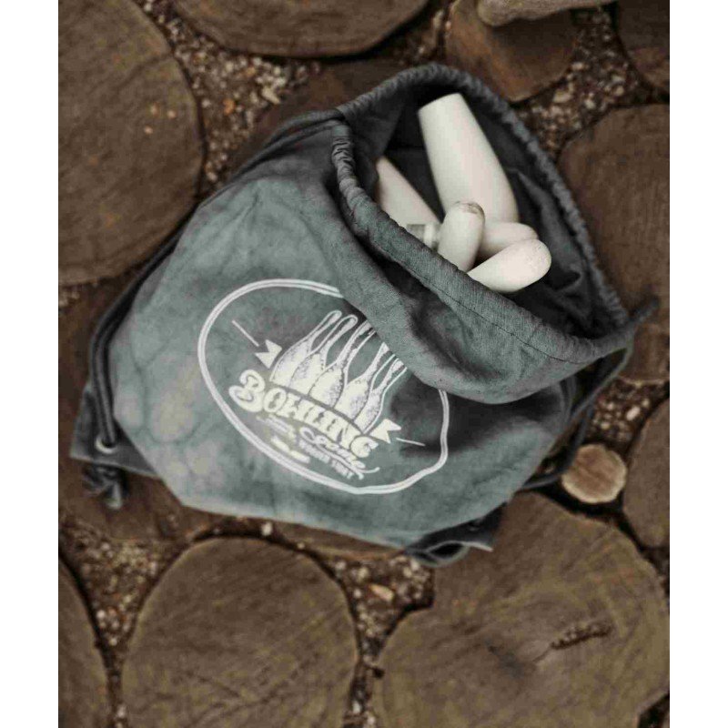 4. Flat lay of wooden bowling pins inside a grey cotton bag with logo on wooden surface