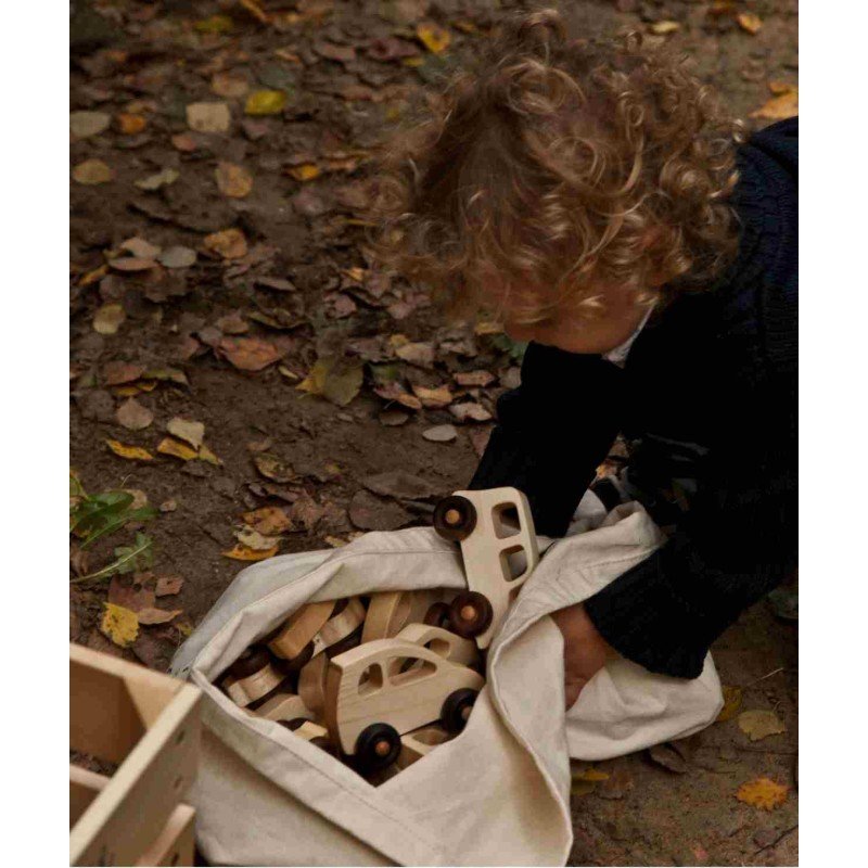 1. Child playing with multiple 1950s Wooden Story cars in a natural outdoor setting