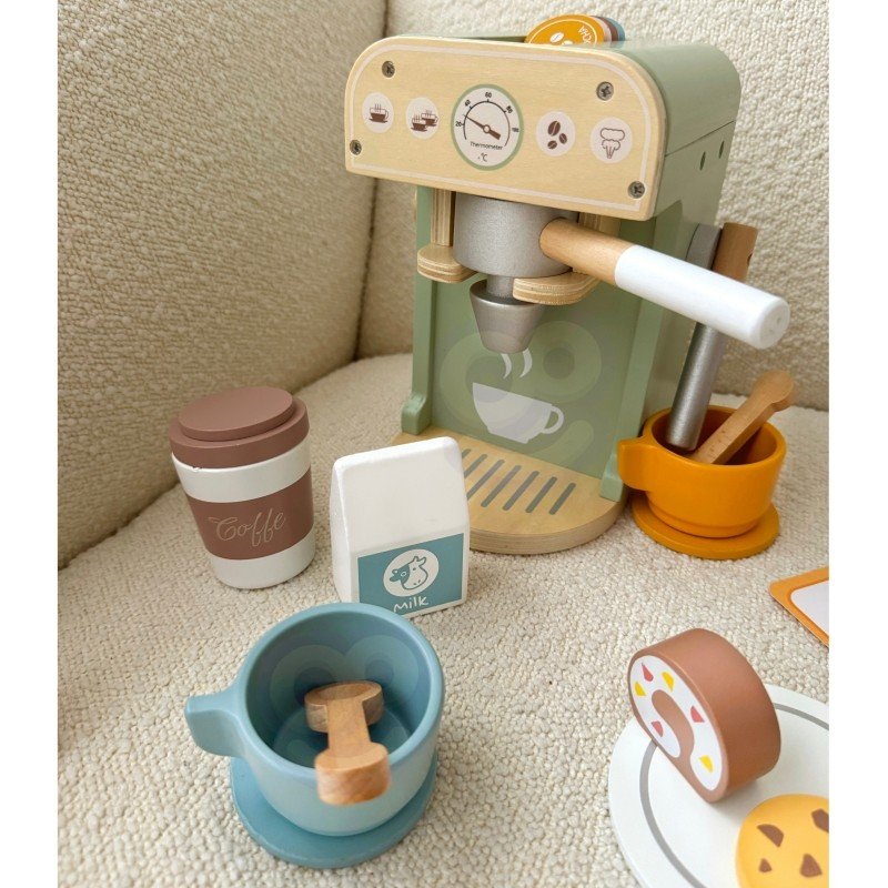 1. Woopie Green barista set on textured surface with coffee machine, cups, and pastries