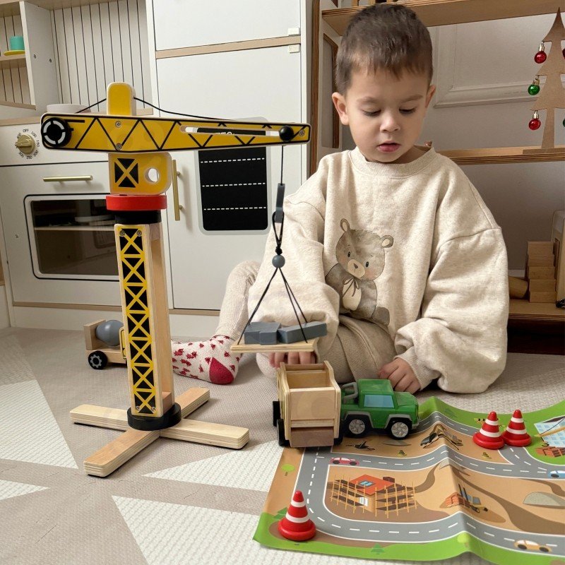 9. Child playing with Woopie Green wooden construction set on a play mat