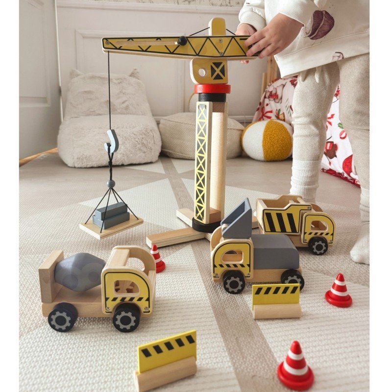 3. Child interacting with Woopie Green wooden crane and vehicles on a carpet