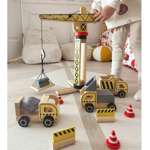 3. Child interacting with Woopie Green wooden crane and vehicles on a carpet