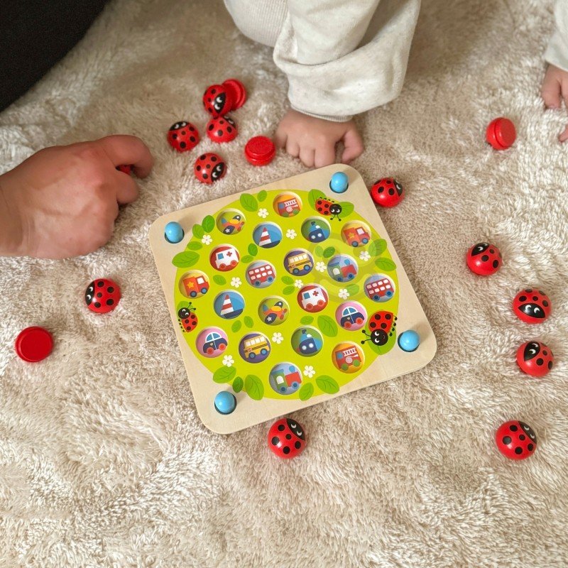 11. Family playing with Woopie Let's Go Green ladybug memory puzzle on a carpet