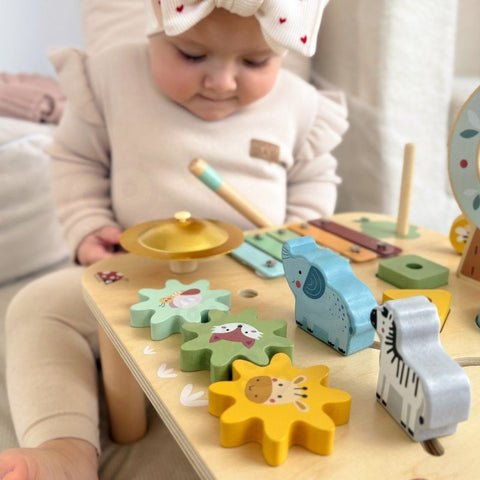 2. Close-up of toddler interacting with Woopie 5-in-1 activity table showing gears and animal shapes