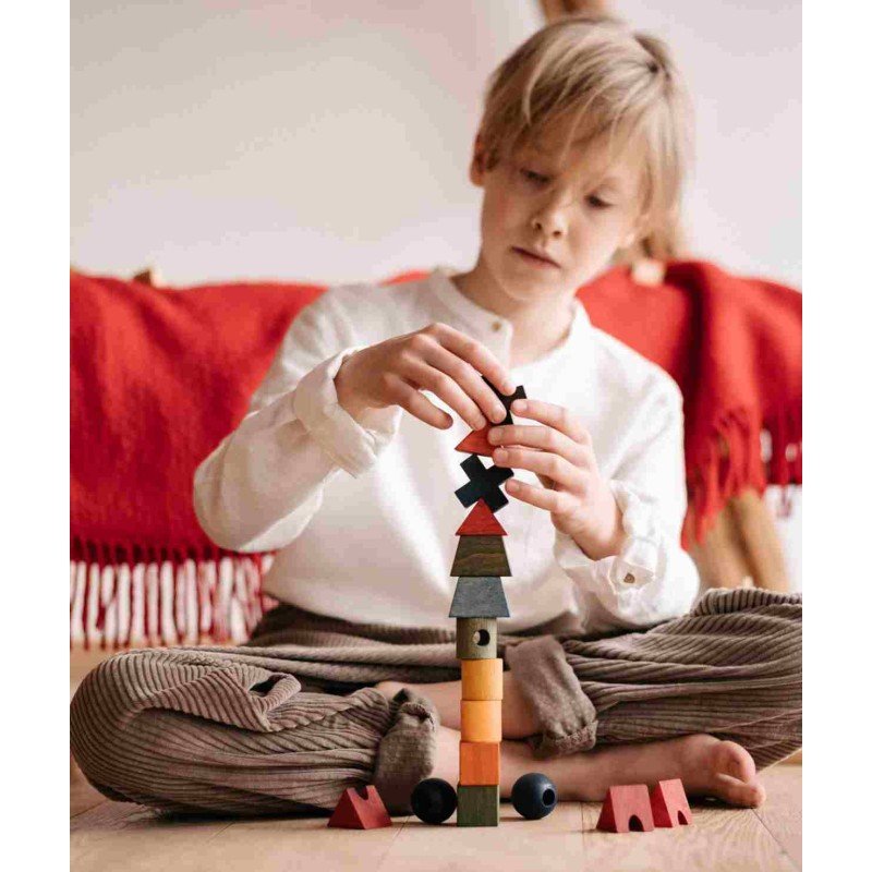 1. Child playing with colorful wooden fence puzzle blocks indoors, focusing on creativity and logical thinking