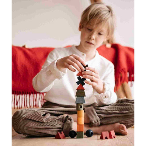 1. Child playing with colorful wooden fence puzzle blocks indoors, focusing on creativity and logical thinking
