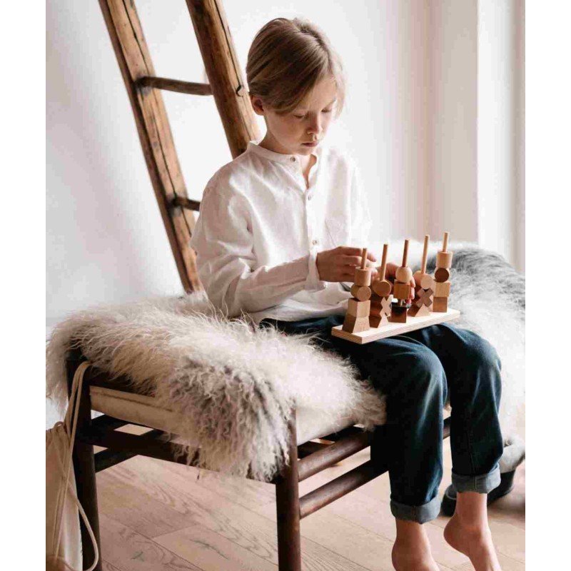 1. Child playing with Wooden Fence Puzzle by Wooden Story while sitting on a chair indoors