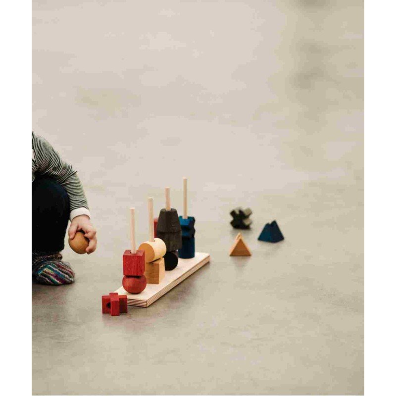 1. Toddler playing with colorful wooden fence puzzle on a smooth floor, with blocks scattered around