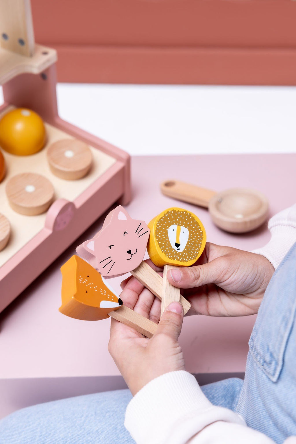 3. Close-up of hands holding animal-shaped ice lollies from wooden ice cream shop