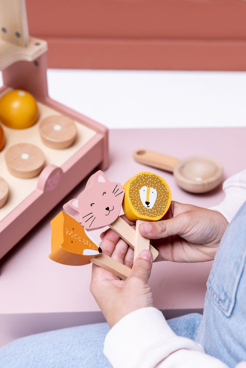 3. Close-up of hands holding animal-shaped ice lollies from wooden ice cream shop