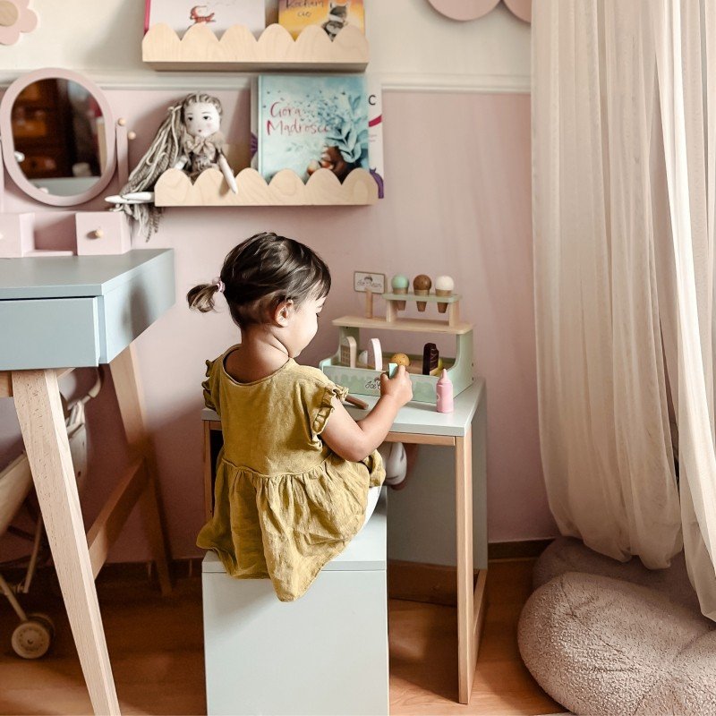11. Back view of girl playing with Woopie Green ice cream stand in a cozy playroom