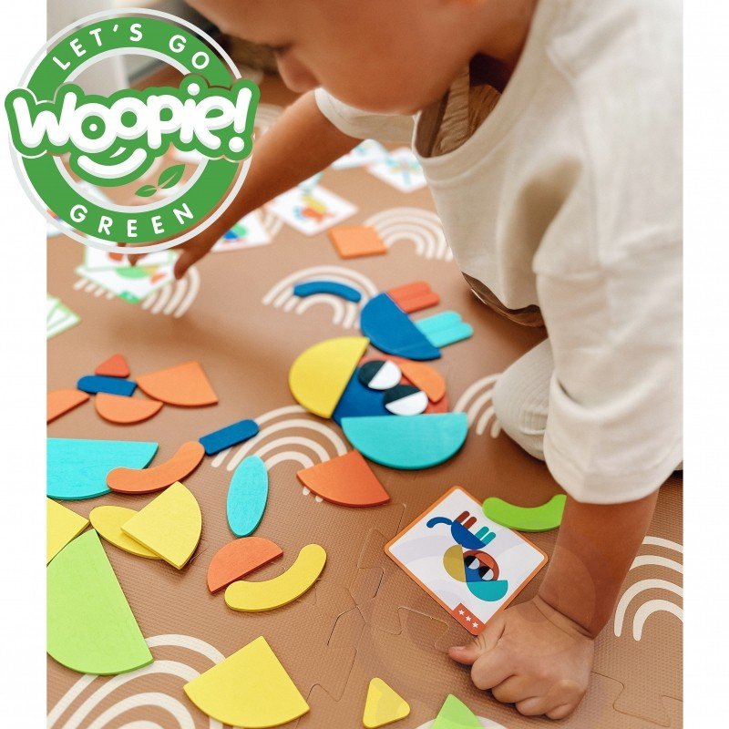 9. Child playing with colorful wooden blocks on table with Woopie Let's Go Green logo