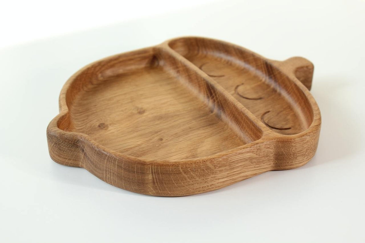 4. Side view of wooden acorn-shaped plate for kids with two compartments on a white background