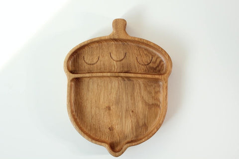 3. Wooden acorn-shaped plate for kids with two compartments on a white background