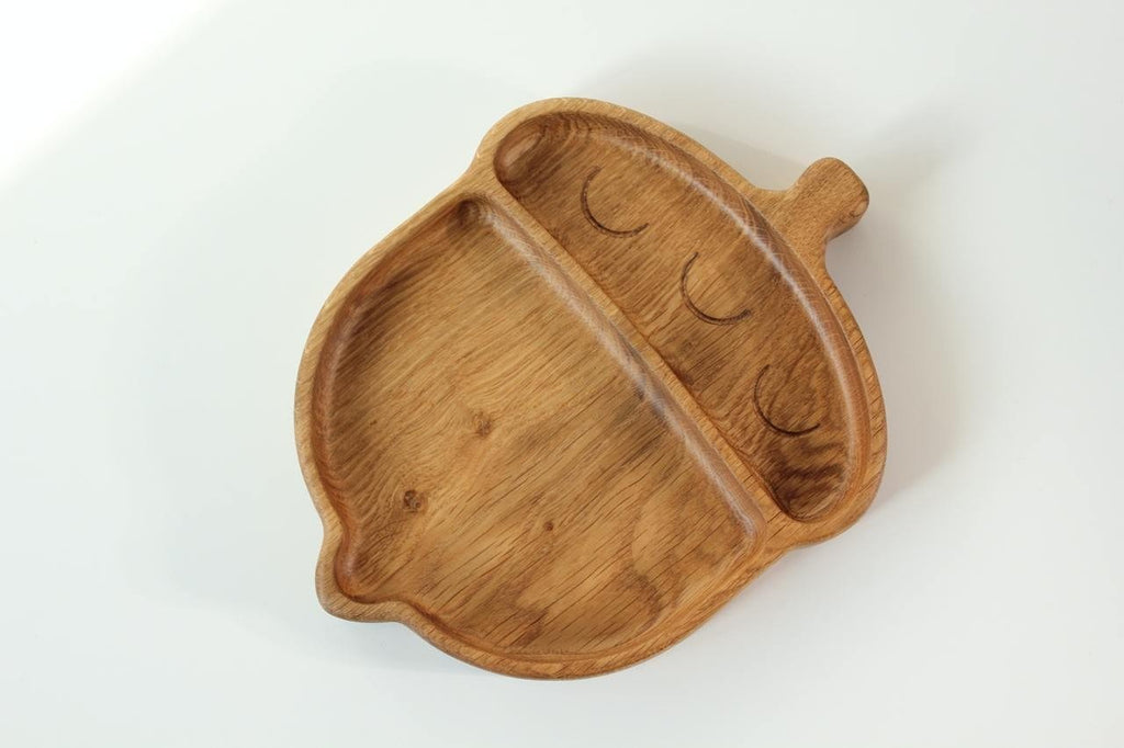 1. Handmade wooden acorn-shaped plate for kids with two compartments on a white background