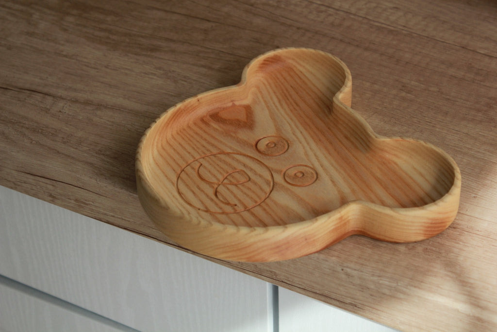 10. Wooden bear-shaped plate on wooden surface, highlighting natural wood grain and smooth finish
