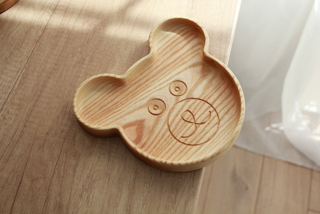 1. Handmade wooden bear-shaped plate on wooden surface, showcasing smooth finish and natural wood grain