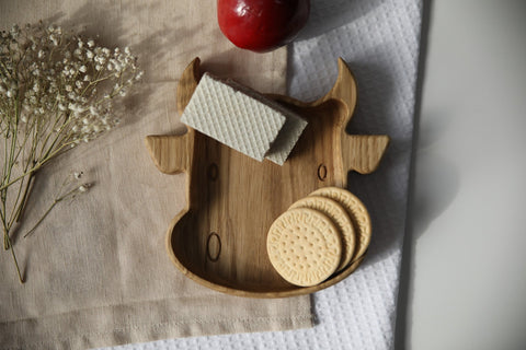 4. Wooden bull-shaped plate with cookies and napkin on textured fabric