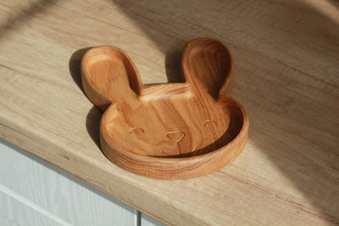 3. Single oak wooden bunny plate on a light wood surface with natural lighting