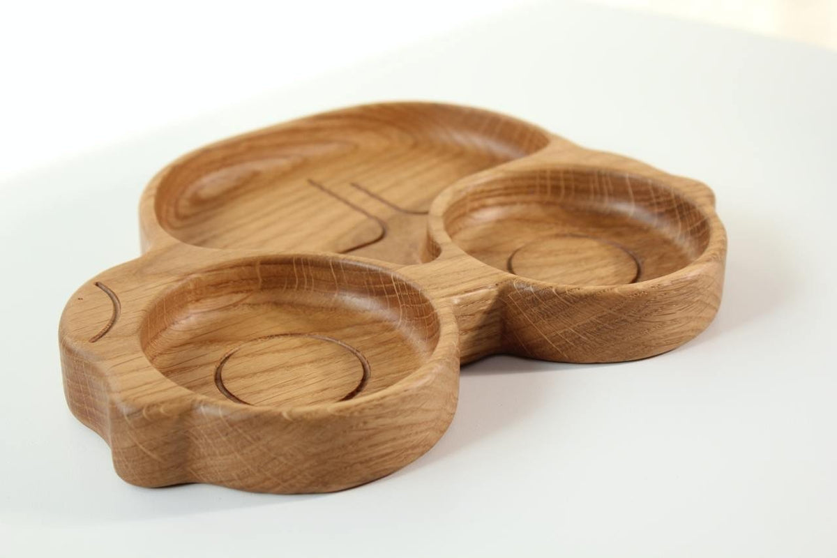 2. Side view of wooden car-shaped plate for kids with two circular sections, crafted from oak, on a white surface