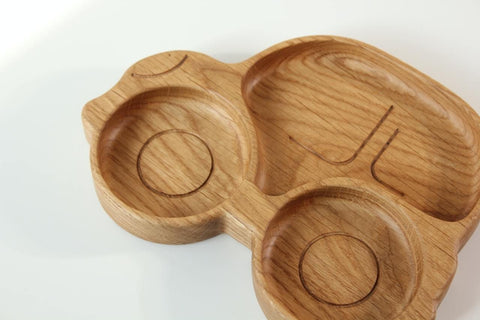 4. Close-up of wooden car-shaped plate for kids, showing detailed carving and two circular compartments, on a white background