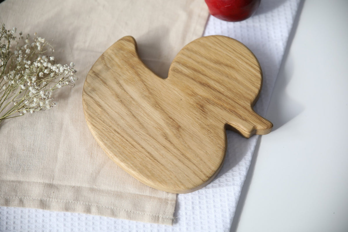 4. Back view of wooden duckling-shaped plate on a beige cloth, highlighting the smooth wood grain texture