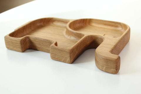 2. Side view of a wooden elephant-shaped kids plate with two sectors, showcasing the natural wood grain