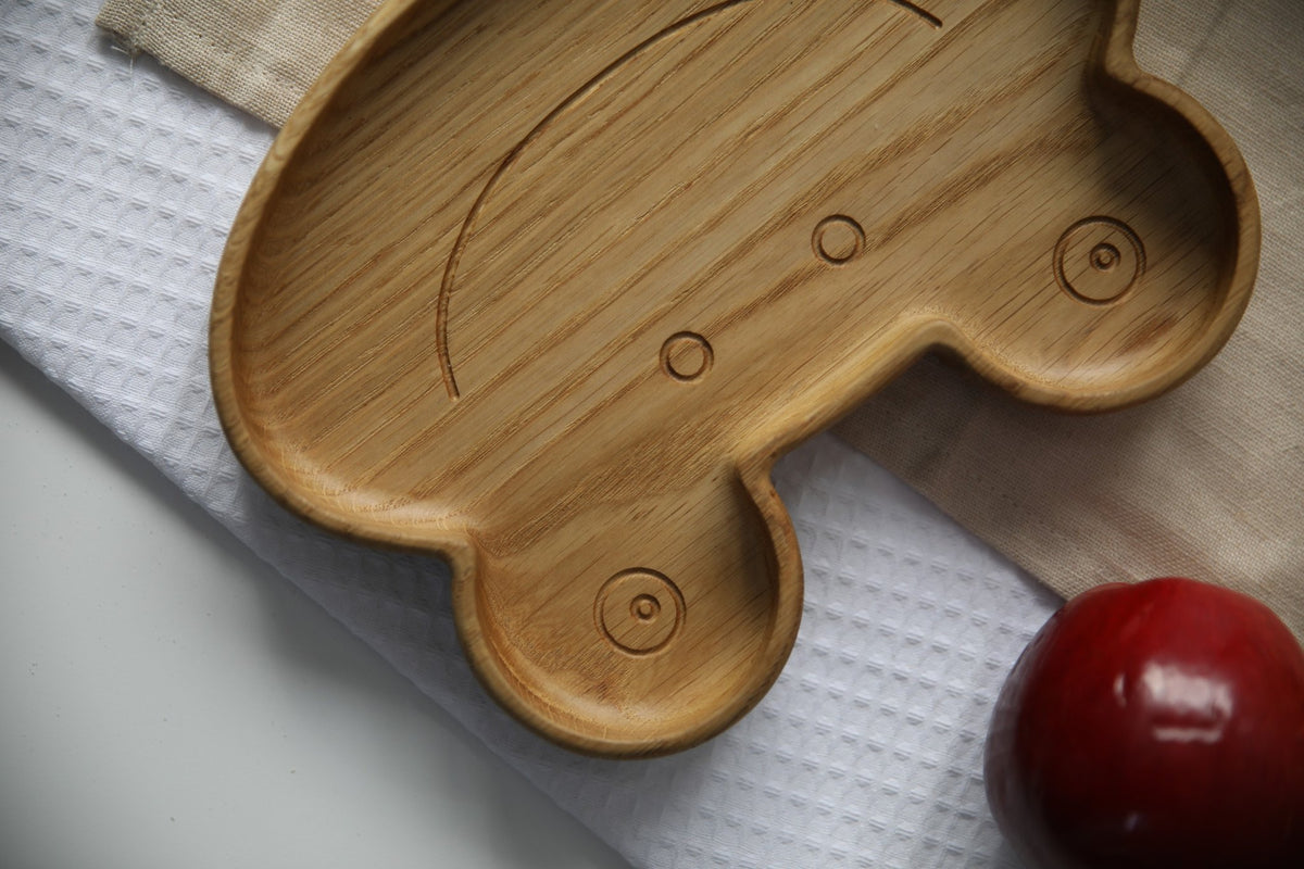 5. Close-up of wooden frog plate with red apple, highlighting carved details and smooth finish