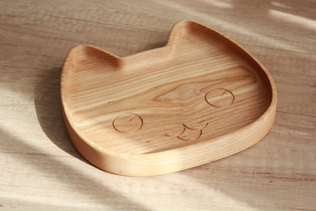 2. Wooden cat-shaped plate for kids on wooden surface, highlighting smooth finish and carved details