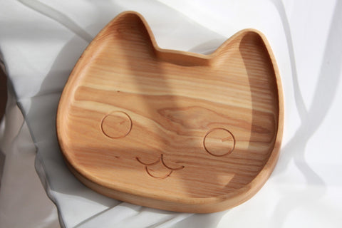 2. Studio shot of wooden cat-shaped plate for kids with smooth, polished surface and carved facial features