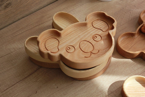 4. Stack of wooden koala-shaped plates on wooden surface, displaying layered design and engraved details