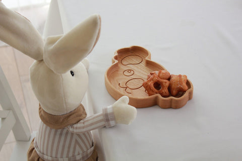 5. Plush rabbit toy next to wooden koala-shaped plate with star-shaped pastries, on a white table