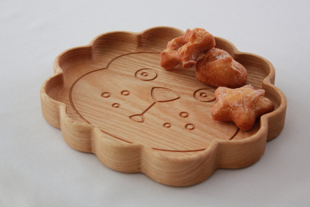 4. Close-up of wooden lion-shaped plate with snacks, showing detailed carving and smooth finish