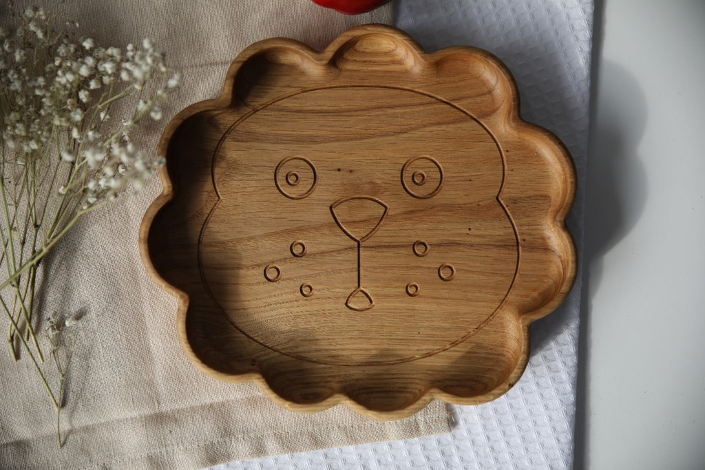 1. Handmade wooden lion-shaped plate on a textured cloth with flowers, showcasing smooth oak or ash finish