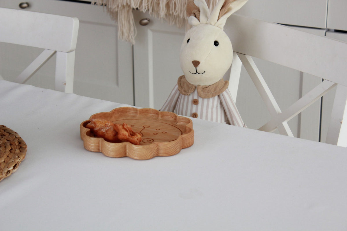 3. Wooden lion-shaped plate with snacks on a table next to a plush toy, emphasizing playful design