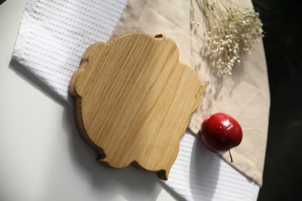 3. Back view of wooden owl-shaped plate highlighting smooth, polished surface on a white and beige cloth