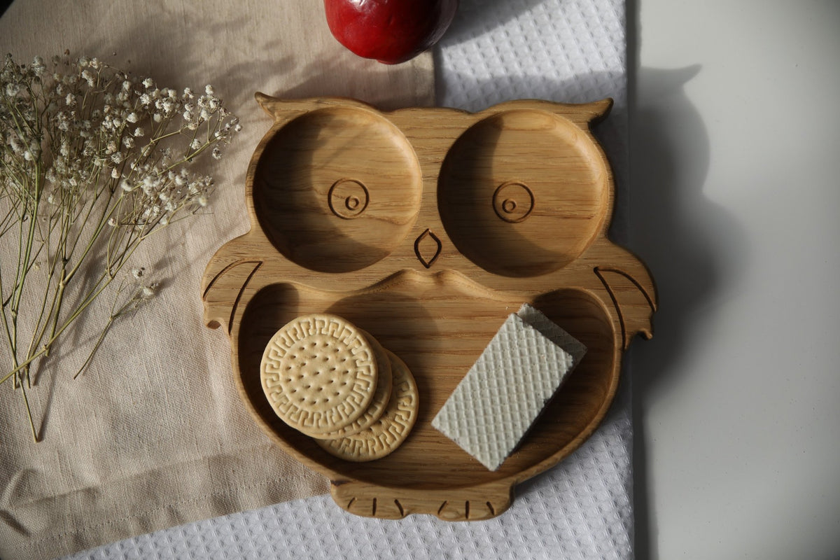 1. Handmade wooden owl-shaped plate with cookies and wafer on a textured cloth background, featuring natural oak or ash wood