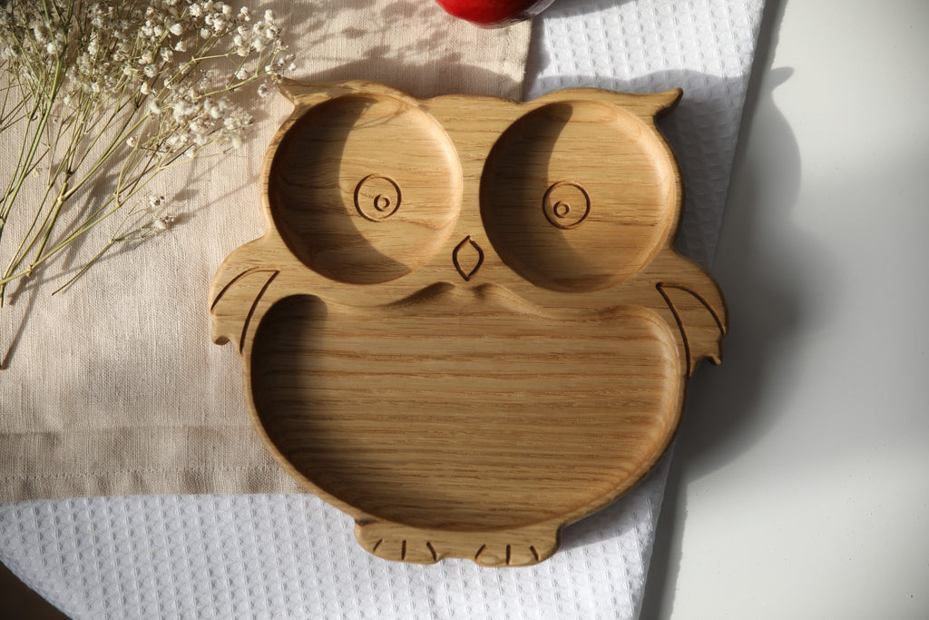 4. Flat lay of wooden owl-shaped plate on a textured cloth, showcasing detailed carving and natural wood grain