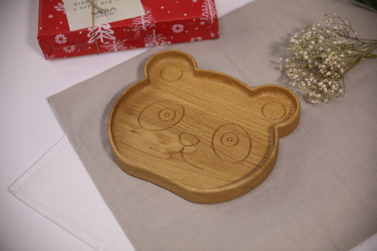 6. Wooden panda-shaped plate for kids on beige cloth with red gift box and flowers