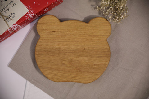 2. Back view of wooden panda-shaped plate for kids on beige cloth with red gift box
