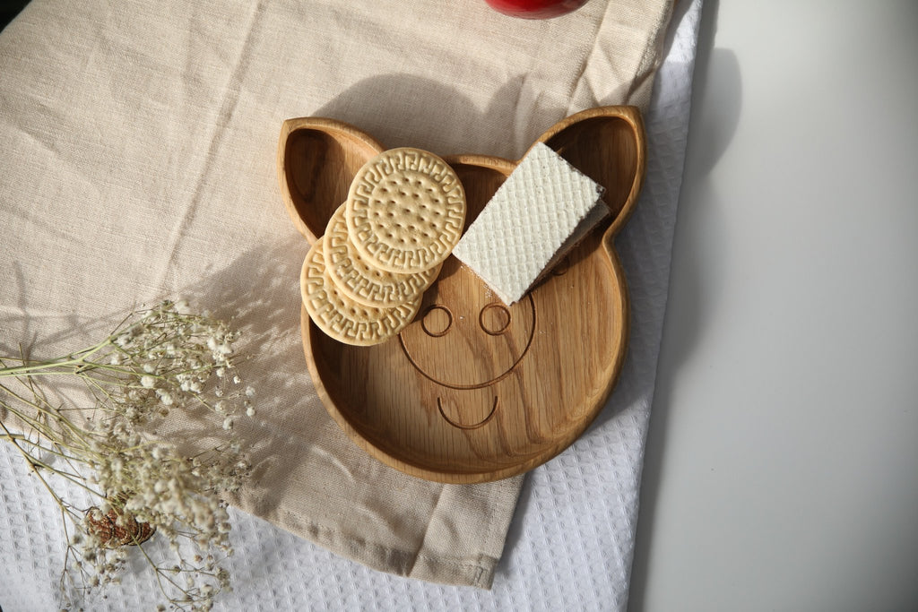 6. Wooden pig-shaped plate with cookies and wafers on a beige fabric with flowers