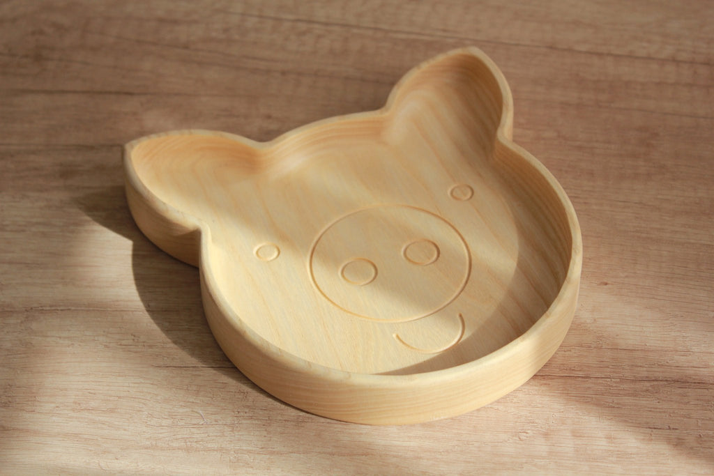 4. Light wood pig-shaped plate on wooden surface, highlighting smooth finish