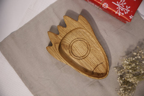 2. Wooden rocket-shaped plate for kids on a beige cloth with a red gift box and flowers, showcasing its natural oak or ash material
